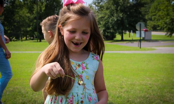 Girl holds up butterfly